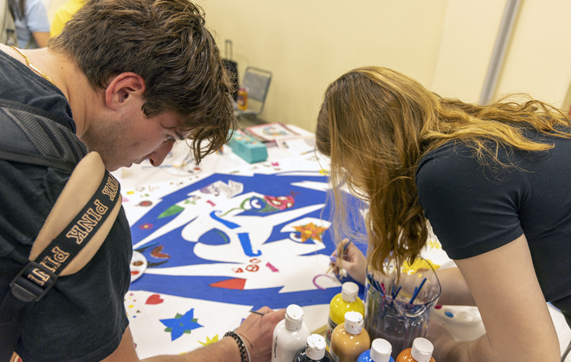 Students collaborating on husky poster.